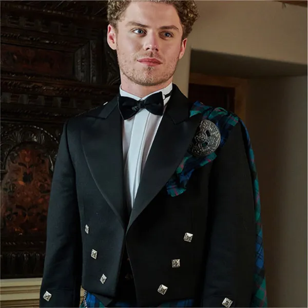 Young man wearing a Traditional Scottish Kilt outfit with our Prince Charlie jacket and 3 button waistcoat shown in a black barathea cloth. He is also wearing a dress sporran and bowtie.